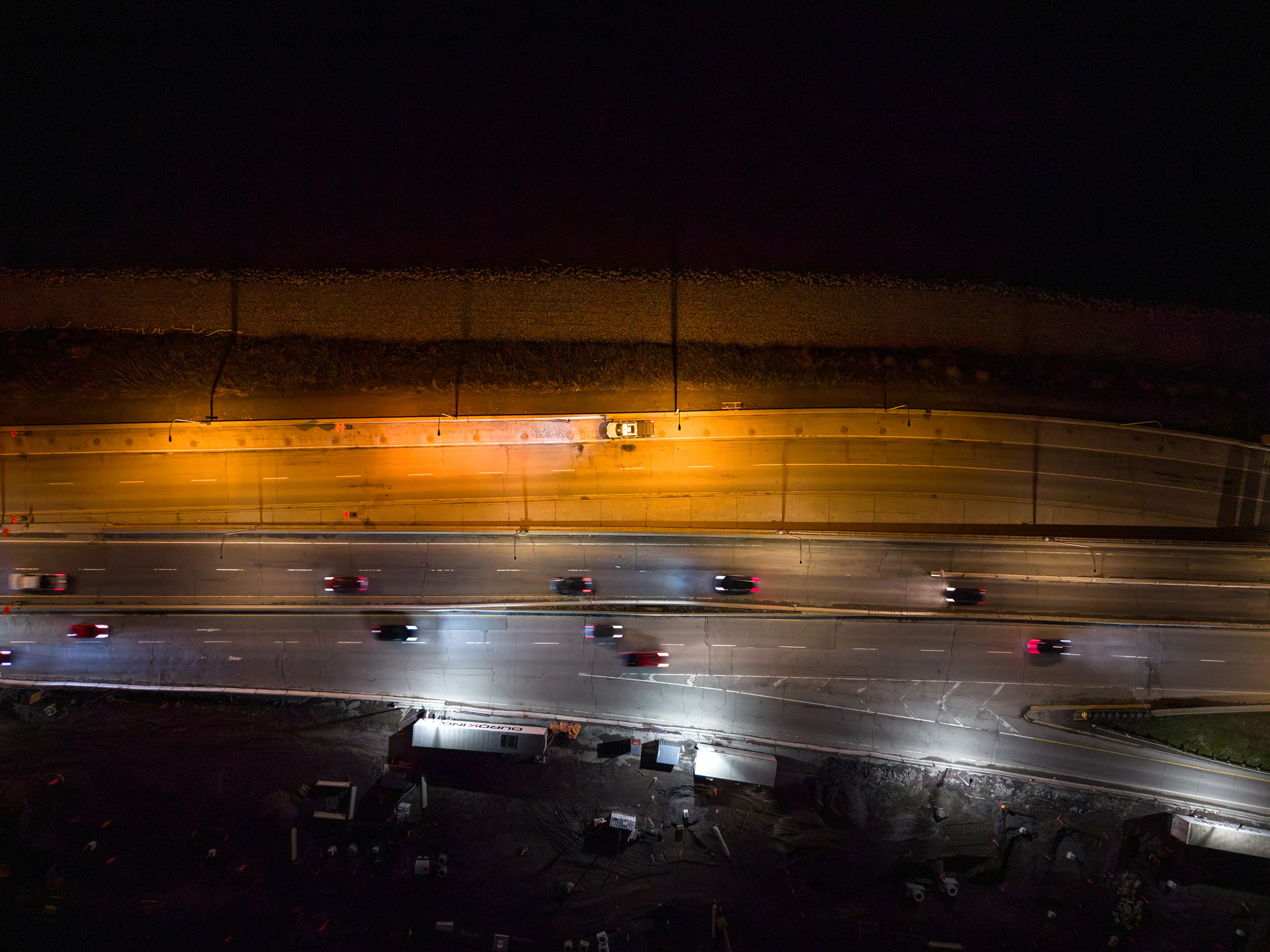 Vue aérienne nocturne de l'autoroute Bonaventure pendant les travaux, circulation en arrière-plan.